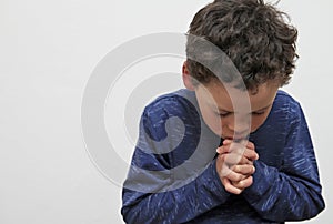 Boy praying to God with hands together stock phot