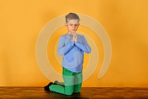 A boy prays kneeling, religious and devout children