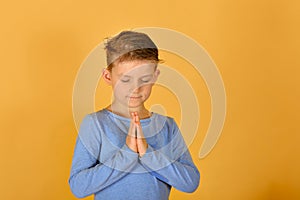 A boy prays kneeling, religious and devout children