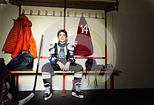 Boy preparing for ice hockey game in locker room