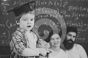 Boy presenting his knowledge to mom and dad. Support concept. Kid holds teddy bear and performing. Parents listening