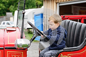 Boy Pretending to Drive an Old Fire Truck