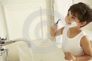 Boy Pretending To Shave In Bathroom Mirror photo