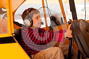 Boy pretends to fly Piper Cub airplane photo