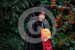 Boy of primary school age in a black-red cloak portrays the evil sorcerer.