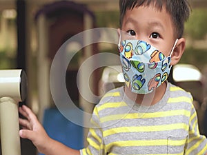 boy in protective medical mask on blurred background at playground