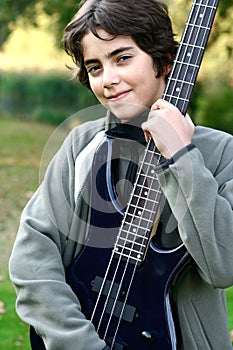 Boy proudly showing off his accoustic guitar.
