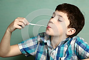 Boy pull chewing gum with his hand from moth