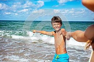 Boy pull parent to the sea pulling hand