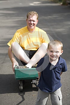 Boy pulling dad in wagon