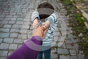 The boy is pulling his father`s hand.