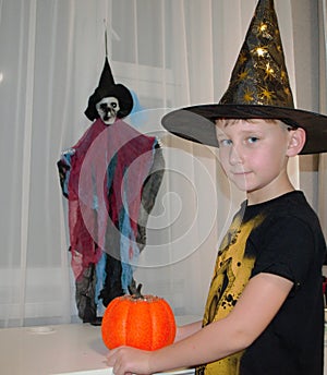 Boy with pumpkin and skeleton, candles. Halloween night