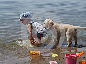 The boy and puppy playing in the river