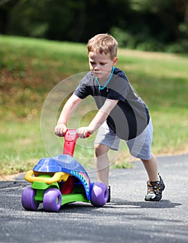 Boy pushing toy bike