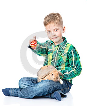 Boy with rabbit showing easter egg. Isolated on white background