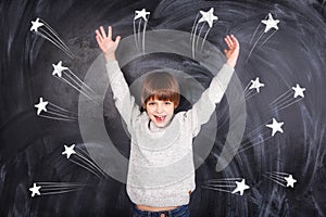 The boy raised his hands to the top and on the chalkboard stars