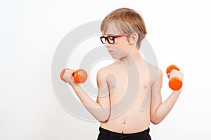 Boy raising a dumbbell. Cute child training with dumbbells, isolated on white. Children fitness