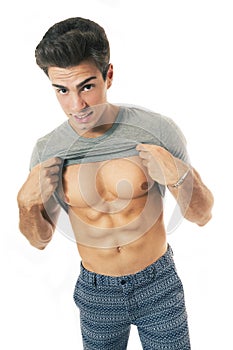 Boy raising his shirt showing abdominal on white background
