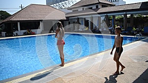 Boy ran stealthily up to girls at pool and pushed her in water. hotel with pool