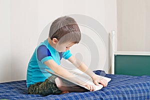 Boy reading book on bed