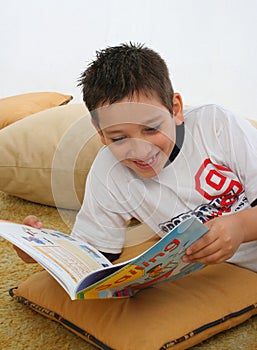 Boy reading a book on the floor