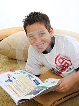 Boy reading a book on the floor