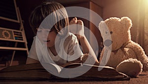 Boy reading book with his teddy bear