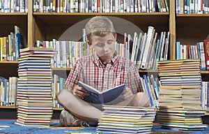 Boy Reading Book In Library