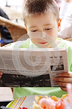 Boy reading newspaper