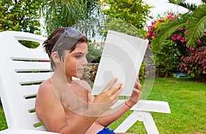 Boy reading on summer lawn