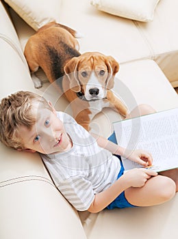 Boy reading tales for his dog at home