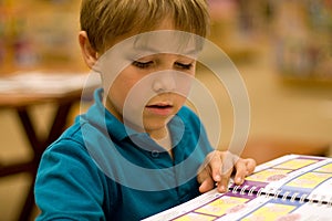 Boy reads a book at libary photo