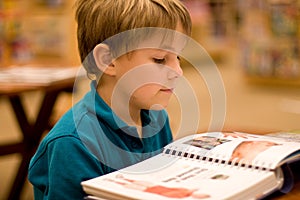 Boy reads a book at libary photo