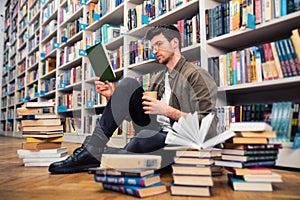 Boy reads a book in a library. Concept of curiosity, imagination and culture