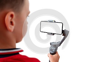 Boy is recording with a mobile phone on the gimbal photo