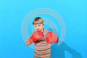 A boy in red boxing gloves makes an attacker punch