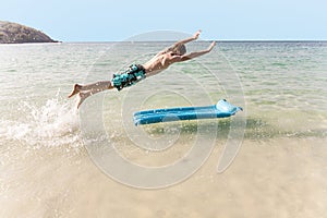 Boy with red hair is enjoying jumping on the air mattress