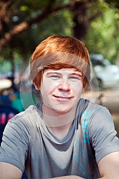 Boy with red hair and pickax in the face looks happy