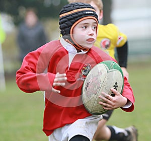 Boy with red jacket play rugby