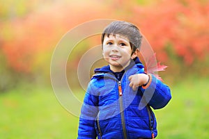 Boy with a red maple leaf attached in the heart region with great pride as Canadian citizen. Portrait of little white Caucasian b