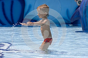 Boy in the red melting plays with water