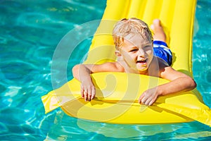 Boy Relaxing and Having Fun in Swimming Pool on Yellow Raft