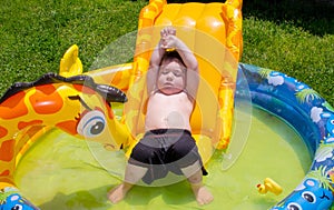 Boy relaxing in the sun on his inflatable pool