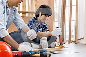 Boy remove nail from timber using hammer.