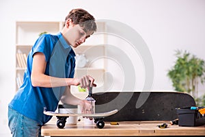 Boy reparing skateboard at home