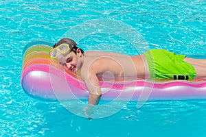 Boy resting on lilo in pool