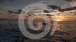 Boy resting and watching the sunset on his paddle surf