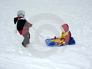 Boy ride baby on sled