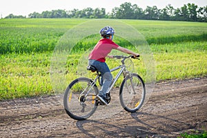 Boy ride on bike at rural road