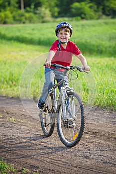 Boy ride on bike on rural road